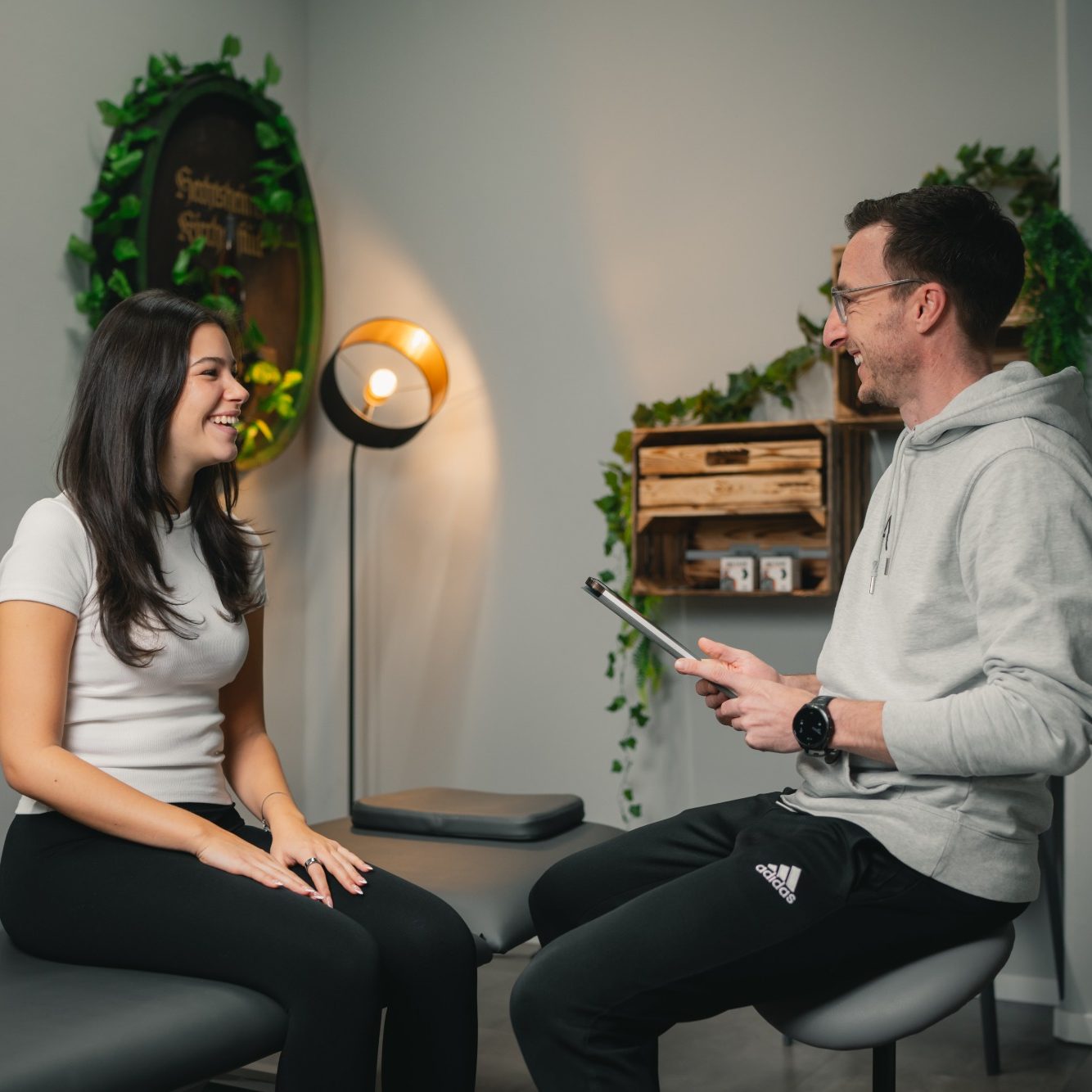 Ein Therapeut behandelt eine liegende Patientin manuell.