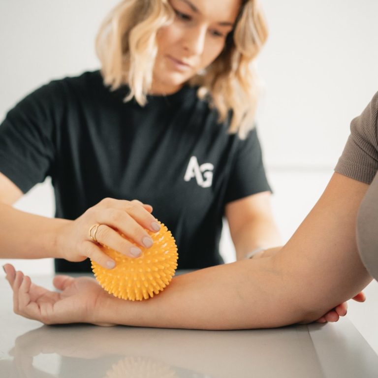 Eine Person erhält eine manuelle Behandlung auf einer Liege.