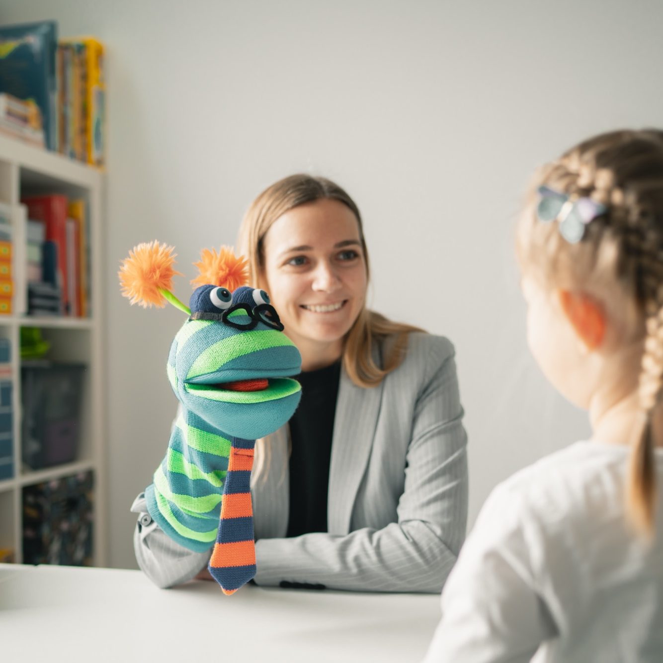 Ein Therapeut behandelt eine liegende Patientin manuell.